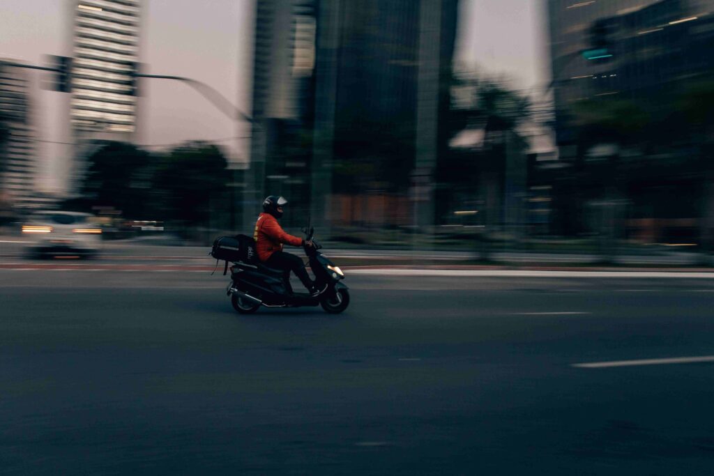 A MannaEV Smart Electric Motorcycle gracefully navigates Malta's streets, showcasing sustainable and efficient same-day on-demand delivery.